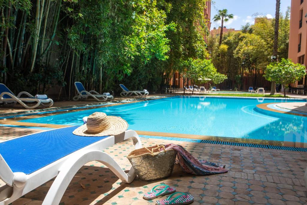 Hotel Meriem – Zwembad met ligbed en strohoed, Marrakech