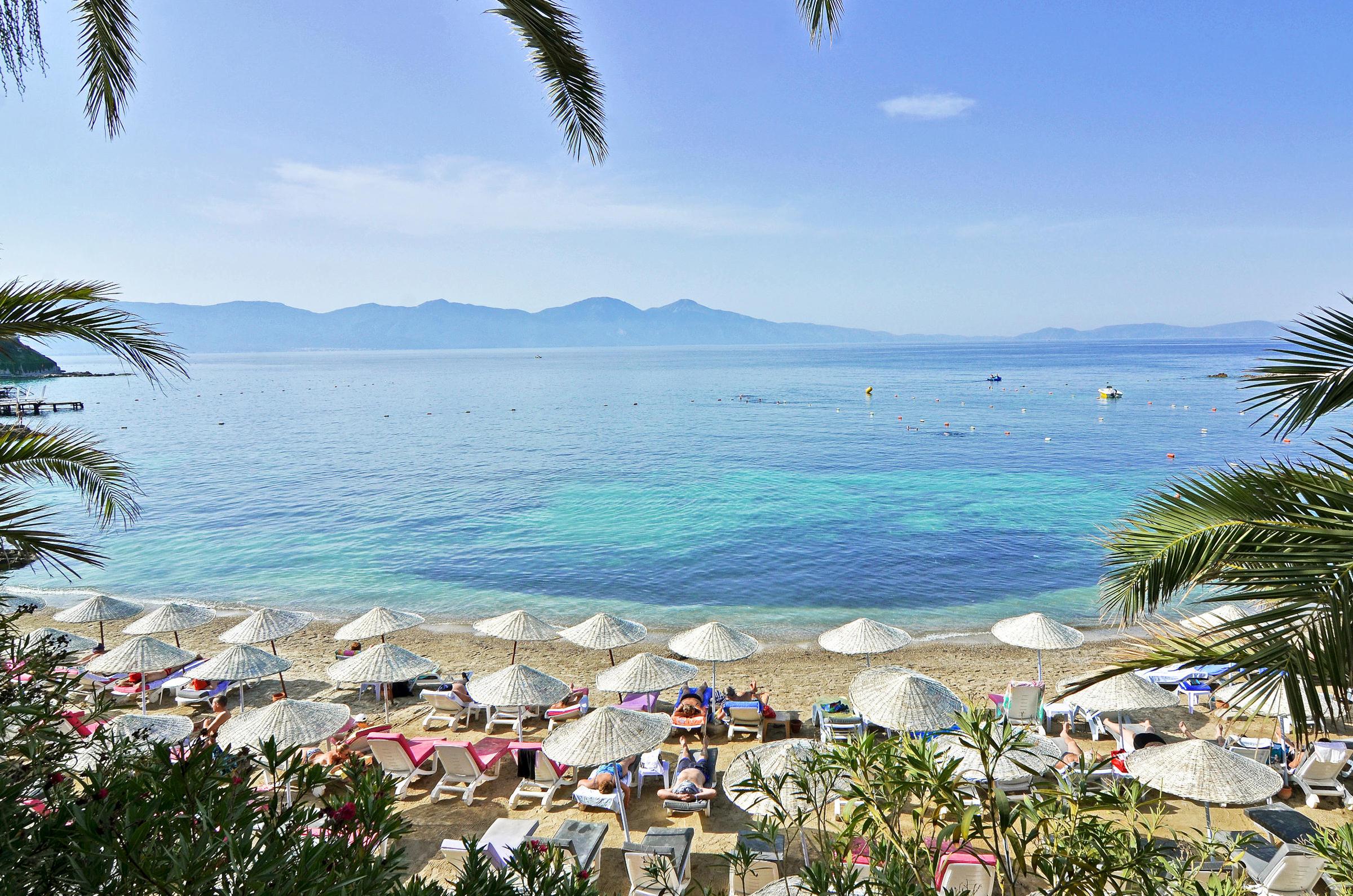 The Grand Blue Sky International – Strand met parasols en turquoise zee, Kusadasi
