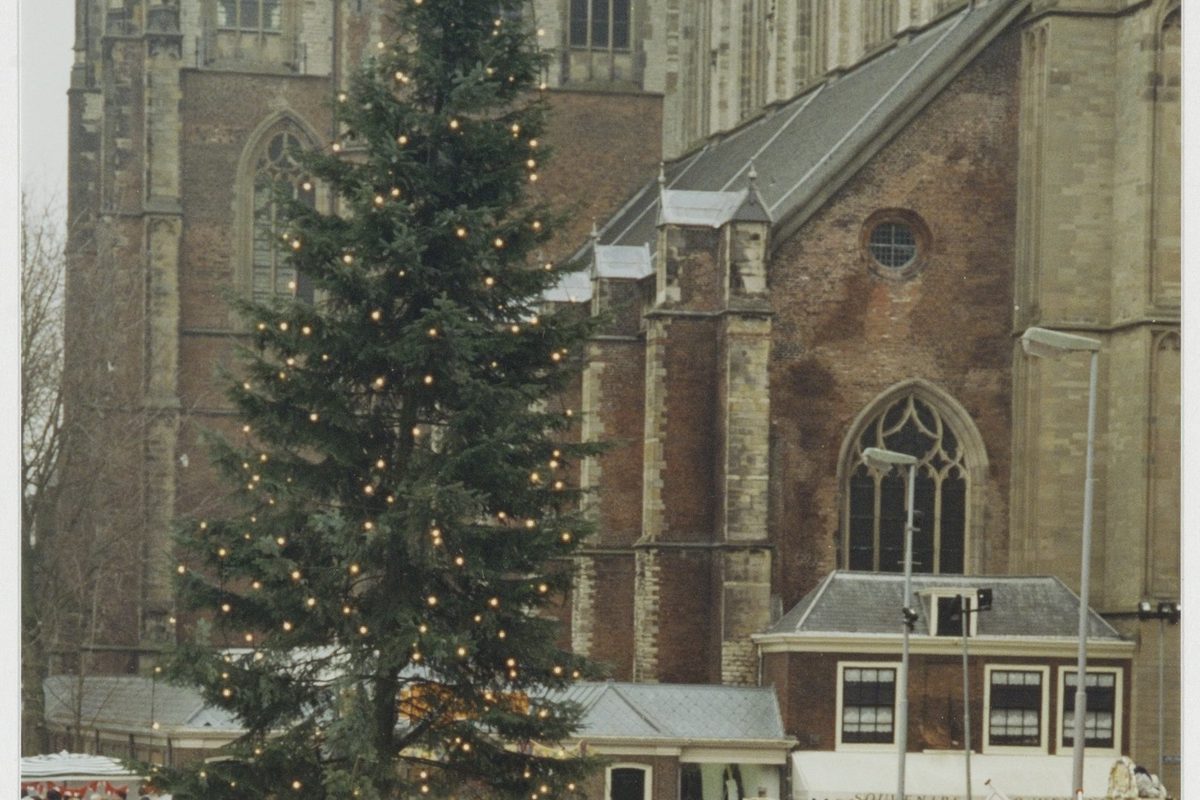 De kerstmarkt op de Grote Markt, met de kerstboom voor de Grote Kerk
